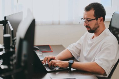 Çeşitli ofislerde bilgisayar üzerinde çalışan profesyonel bir programcı portresi. Modern bilişim teknolojileri, yapay zekanın geliştirilmesi, programlar, uygulamalar ve video oyunları konsepti