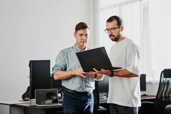 Portrait of two professional male programmers working on computer in diverse offices. Modern IT technologies, development of artificial intelligence, programs, applications and video games concept