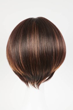 Beyaz manken kafasında doğal görünümlü esmer peruk. Plastik peruk tutacağında kısa kahverengi saç, beyaz arka planda izole edilmiş.