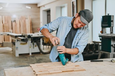 Marangoz marangozluk atölyesinde ahşapla çalışır. Adam profesyonel olarak ahşap işi yapıyor.