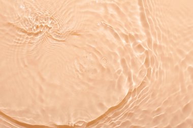 Su bej yüzeyi soyut arkaplan. Kabarcıklı kozmetik su nemlendiricisinin dalgaları ve dalgaları