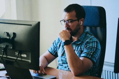 Çeşitli ofislerde bilgisayar üzerinde çalışan profesyonel bir programcı portresi. Modern bilişim teknolojileri, yapay zekanın geliştirilmesi, programlar, uygulamalar ve video oyunları konsepti