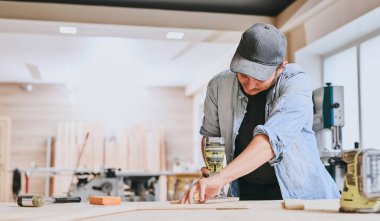 Marangoz marangozluk atölyesinde ahşapla çalışır. Adam profesyonel olarak ahşap işi yapıyor.