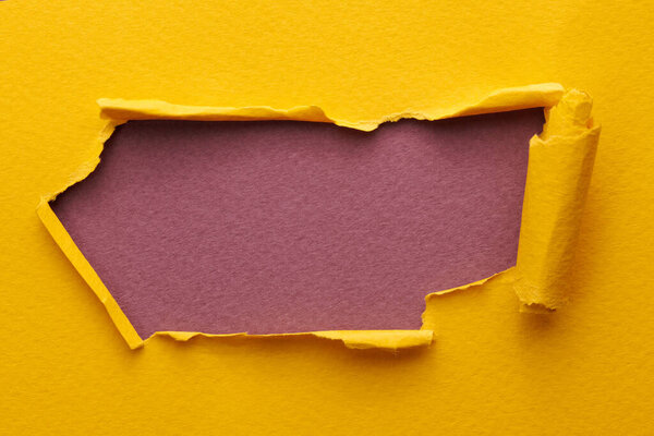 Frame of ripped paper with torn edges. Window for text with copy space yellow burgundy red colors, shreds of notebook pages. Abstract backgroun