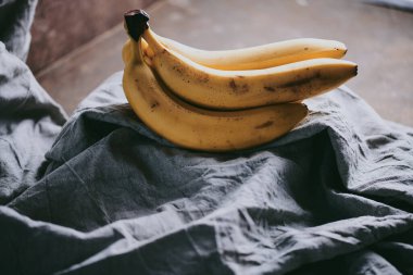 Koyu renk kumaş arka planda bir grup muzun yakın çekimi