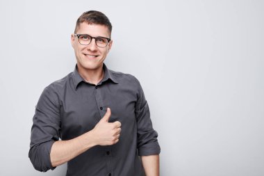 Beyaz stüdyo arka planında izole edilmiş, sevinçle gülümseyen genç beyaz adamın portresi. Doğru seçimi, doğru kararı onaylar