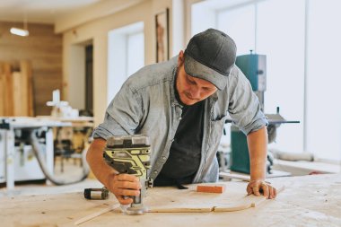 Marangoz marangozluk atölyesinde ahşapla çalışır. Adam profesyonel olarak ahşap işi yapıyor.