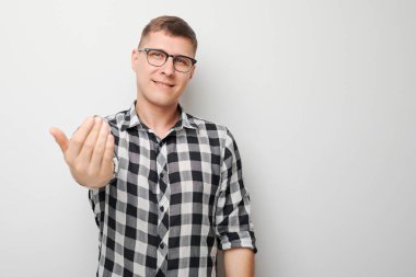 Kendine güvenen bir adamın portresi beyaz stüdyo arka planında izole edilmiş kamerayı işaret eder. Hoş geldin jesti, takımımıza katıl.