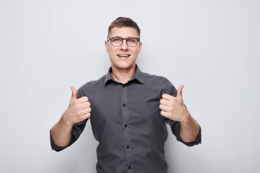 Beyaz stüdyo arka planında izole edilmiş, sevinçle gülümseyen genç beyaz adamın portresi. Doğru seçimi, doğru kararı onaylar