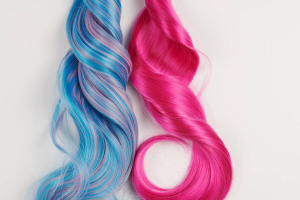 Natural looking shiny hair of different bright colors, cosplay wig on a white background