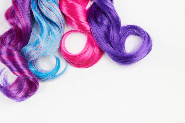 Natural looking shiny hair of different bright colors, cosplay wig on a white background