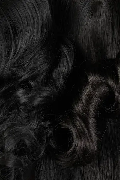 Natural looking shiny hair, bunch of dark brunette colors curls and wigs isolated on black background