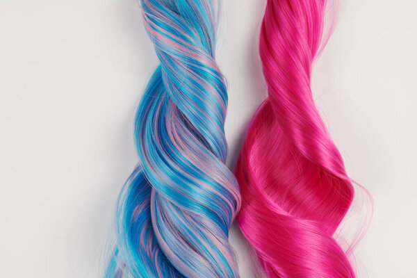 Natural looking shiny hair of different bright colors, cosplay wig on a white background