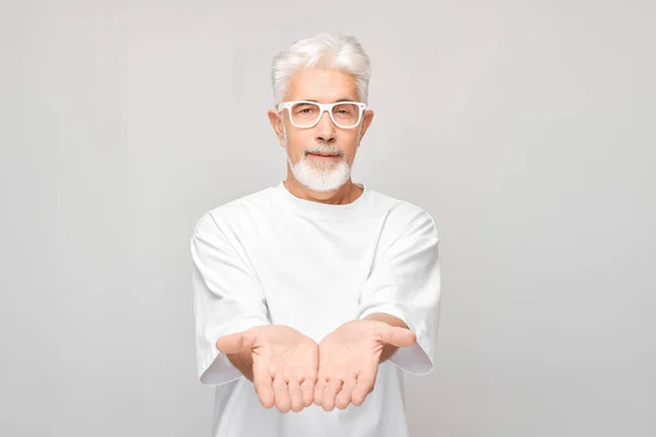 Beyaz Tişörtlü Gri Saçlı Olgun Bir Adam Elinde Bir Şey — Stok fotoğraf