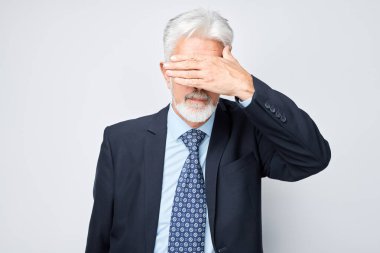 Yaşlı adamın portresi gözleri kaplayan beyaz stüdyo arka grubunda elle izole edilmiş.