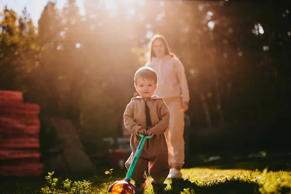 息子との幼い母親の肖像画 幸せな母性 日当たりの良い秋の夜に男の子と遊ぶ女性 — ストック写真