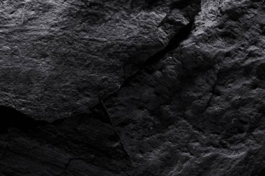 Siyah taş dokusu, koyu soyut arkaplan. Doğal mineral kaya detayları kapat, tasarım için kopya alanı olan boş arkaplan