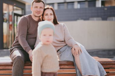 Mutlu aile portresi. Anne, baba ve oğul şehirde geziyor, güneşli bir günde birlikte eğleniyor ve eğleniyorlar.