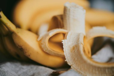 Koyu renk kumaş arka planda bir grup muzun yakın çekimi