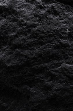 Siyah taş dokusu, koyu soyut arkaplan. Doğal mineral kaya detayları kapat, tasarım için kopya alanı olan boş arkaplan