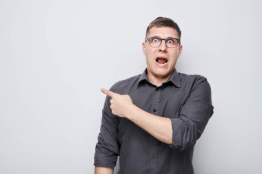 Gözlüklü yakışıklı bir adam, beyaz stüdyo arka grubunda boş alan ve ürün için izole edilmiş metinler gösteriyor.