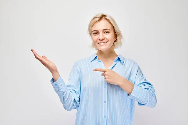 Młoda Blondynka Nieformalnie Trzymająca Coś Ręku Pokazująca Puste Miejsce Produkt — Zdjęcie stockowe