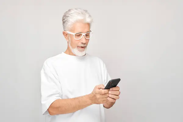 Portrait Gray Haired Man White Shirt Looks Mobile Phone Thinks — Stock Photo, Image