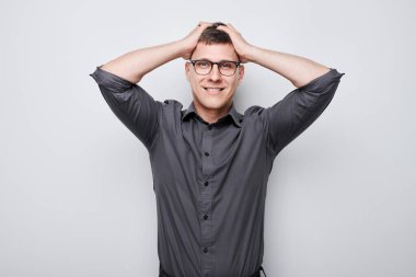 Kafaya dokunan ve sevinen gülümseyen adamın portresi, zaferi kutlayan beyaz stüdyo arka planında izole edilmiş, reklam afişi.