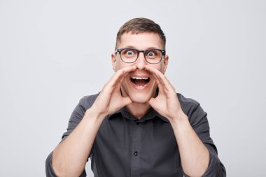 Beyaz arka planda izole edilmiş megafon gibi katlanmış avuçlar, haberlerle bağıran yakışıklı bir adamın portresi.