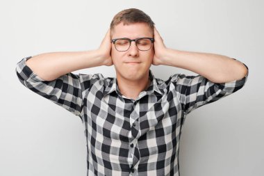 Üzgün suratlı, beyaz arka planda duygusal çöküntü hisseden yorgun adamın portresi. Sinirler, stres, belirsizlik.