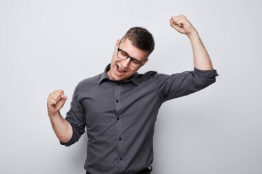 Gülümseyen adamın portresi yumruklarını sıkan ve sevinen, zaferi kutlayan beyaz stüdyo arka planında izole edilmiş, reklam afişi