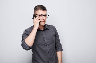 Cep telefonuyla konuşan genç iş adamının portresi. Akıllı telefonu olan kişi beyaz grupta izole edildi