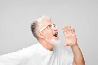 Beyazlar içindeki kıdemli bir adamın portresi. Beyaz arka planda izole edilmiş megafon gibi katlanmış eller, haberler ve avuçlar yüksek sesle bağırıyordu.