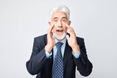 Takım elbiseli kıdemli işadamının portresi, el ve haberlerle bağırıyordu. Avuç içleri megafon gibi kıvrılmıştı.