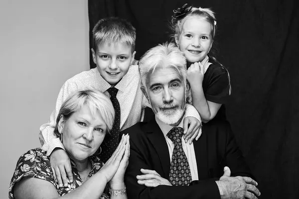 Black and white portrait of a happy family with grandparents and grandchildren smiling together.