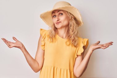 Sarı elbiseli, şapkalı, şaşkın suratlı, omuzlarını silken bir kadın..