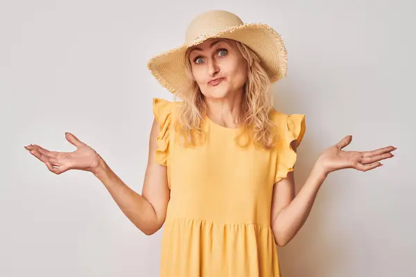 Sarı Elbiseli Şapkalı Şaşkın Suratlı Omuzlarını Silken Bir Kadın — Stok fotoğraf