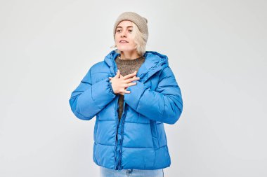 Kışın giyinmiş kadın üşümüş, arka planda soyutlanmış..