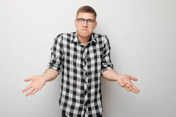 Confused Young Man Checkered Shirt Shrugging Shoulders White Background Expressing — Stock Photo, Image
