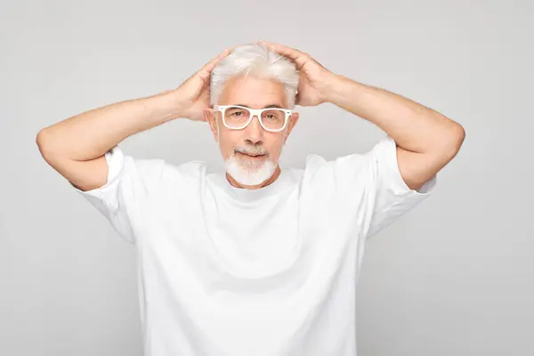 Beyaz Saçlı Gözlüklü Yaşlı Adam Elleri Başının Üstünde Gri Arka — Stok fotoğraf