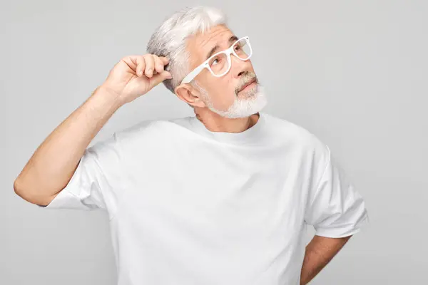 Beyaz Saçlı Gözlüklü Olgun Bir Adam Gri Arka Planda Düşünceli — Stok fotoğraf