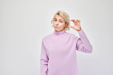 Kafası karışmış genç bir yetişkinin hafif arka planda izole edilmiş küçük bir jest yapması..