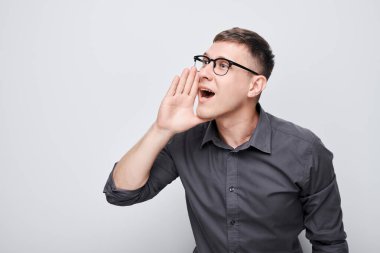 Beyaz arka planda izole edilmiş megafon gibi katlanmış avuçlar, haberlerle bağıran yakışıklı bir adamın portresi.