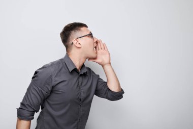 Beyaz arka planda izole edilmiş megafon gibi katlanmış avuçlar, haberlerle bağıran yakışıklı bir adamın portresi.