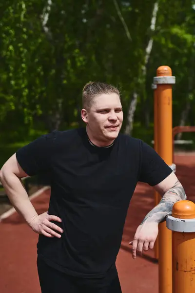 stock image Caucasian male athlete rests between approaches to workout outdoors in a summer park