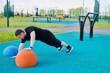Bir erkek sporcu dışarıda spor alanında antrenman yapıyor. Beyaz erkek şınav çekiyor, yaz parkında dışarıda egzersiz yapıyor.