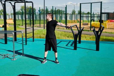 Bir erkek sporcu dışarıda spor alanında antrenman yapıyor. Beyaz erkek sporcu yaz parkında antrenman yapmadan önce ısınma egzersizi yapıyor.