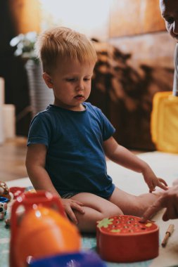 Babasıyla evde oyuncaklarla oynayan küçük bir çocuk. Mutlu baba ve oğul birlikte vakit geçiriyorlar.