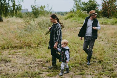 Mutlu bir aile ormanda yürüyüş yapıyor, böğürtlen ve otlar topluyor, patika boyunca seyahat ediyor ve anne ve baba ile çocukları taşlıyor.