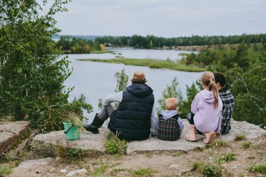 Mutlu bir aile ormanda yürüyüş yapıyor, böğürtlen ve otlar topluyor, patika boyunca seyahat ediyor ve anne ve baba ile çocukları taşlıyor.